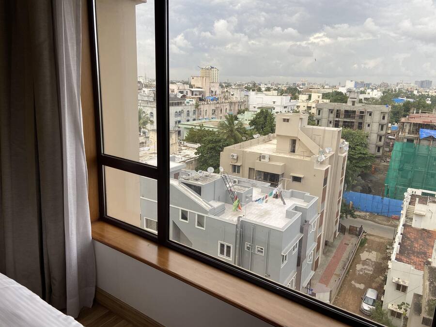 A room with a large window overlooking a cityscape.