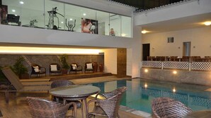 A poolside area with wicker furniture, a table, and a seating arrangement. - Arituba Park Hotel (Natal)