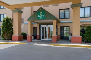 Entrada de hotel con toldo verde que muestra el logotipo de Quality Inn.