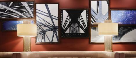 A restaurant with a booth seating area, a table with plates and glasses, and framed pictures on the wall.