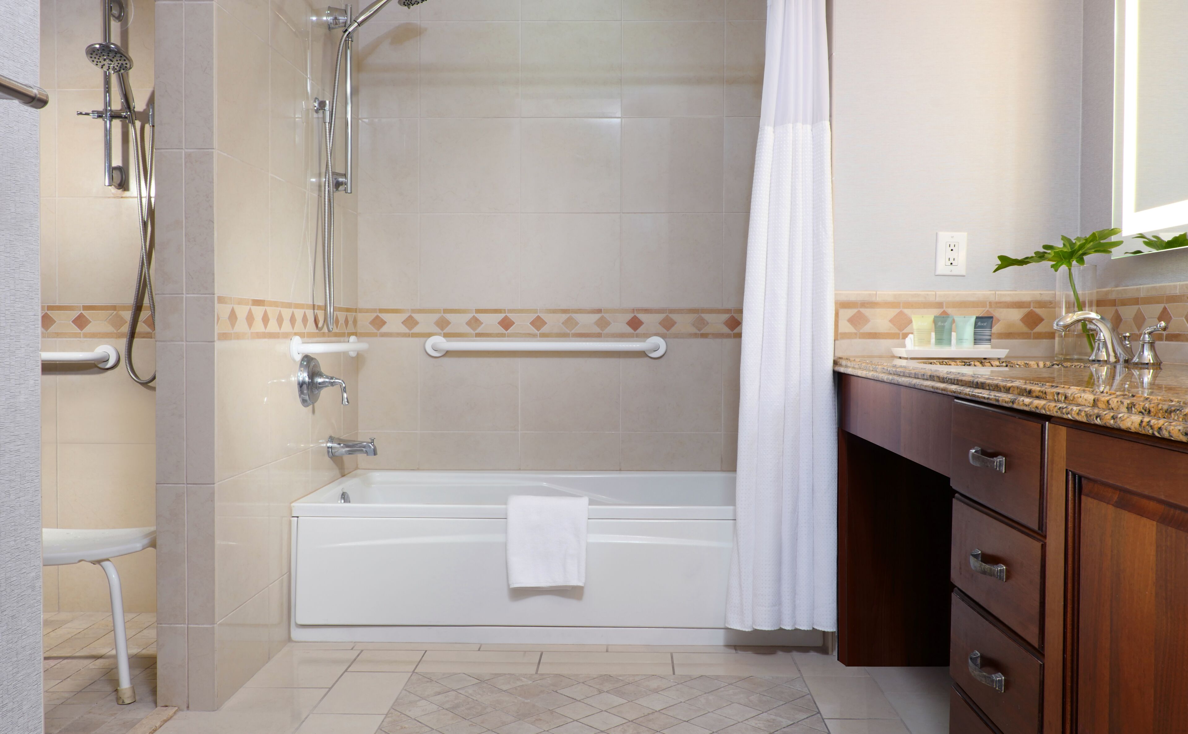 A bathroom with a bathtub, shower, and vanity with a sink and mirror.