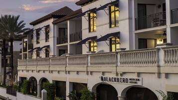 A multi-story hotel with a white facade, balconies, and a sign reading "BLACKBIRD Modern Asian."