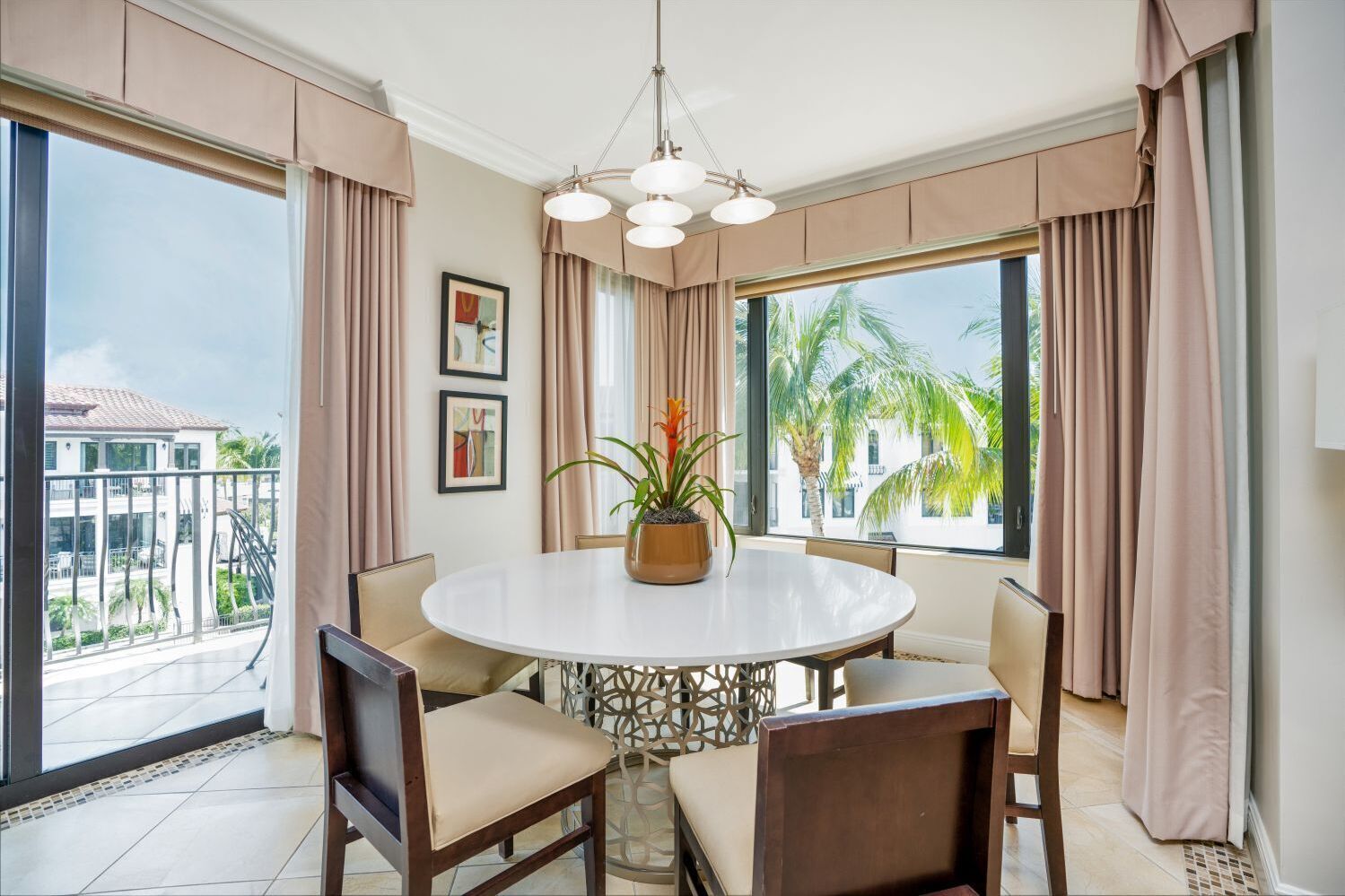 A dining area with a round table, chairs, and a potted plant.