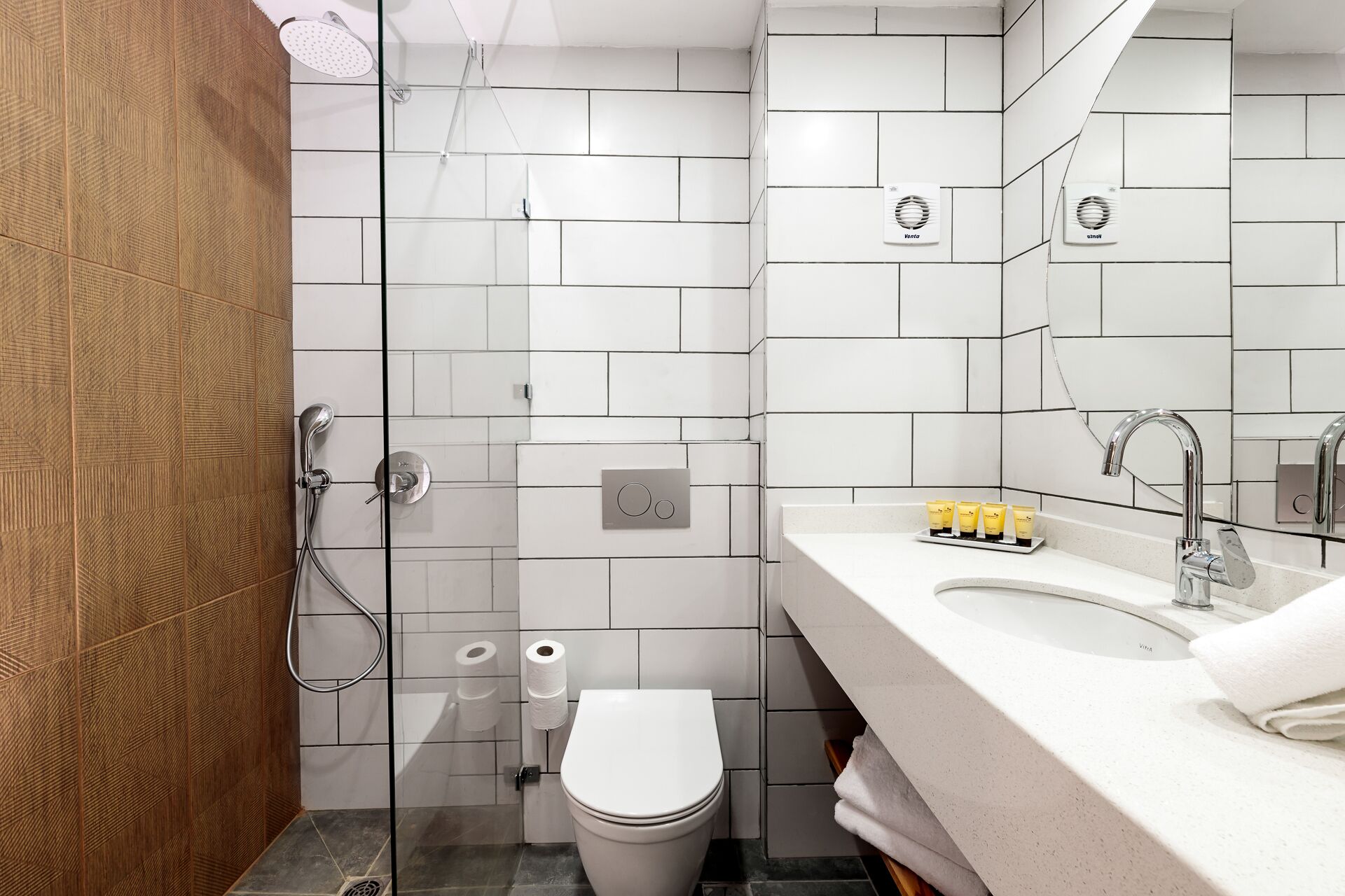 Un baño moderno con ducha, inodoro y lavamanos.
