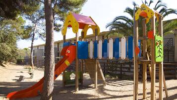 Un parque infantil con tobogán, estructuras para escalar y pared de escalada.