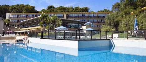 Een seizoensgebonden buitenzwembad en ligstoelen