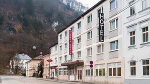 A hotel with multiple floors, a prominent sign, and a mountainous backdrop.
