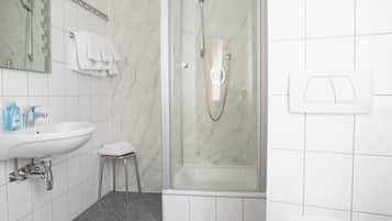 Un bagno moderno con doccia, servizi igienici, lavandino e specchio.