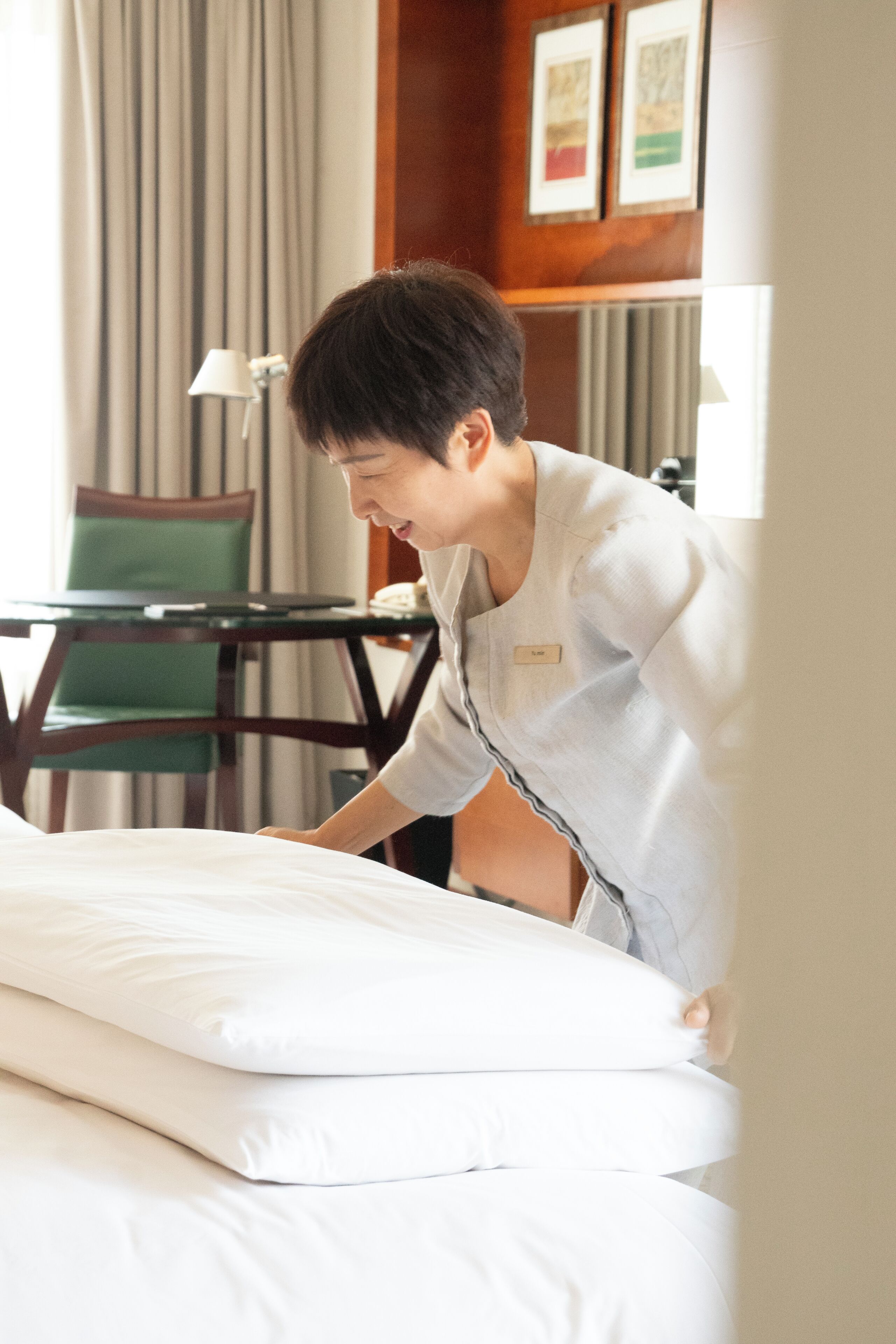 Een hotelkamer met een bed, een stoel, een tafel en een lamp.