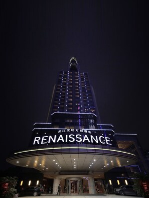 A hotel named Renaissance with a prominent entrance and illuminated signage.