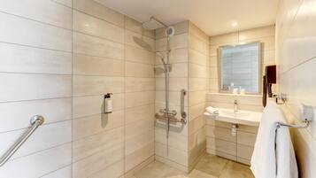 Ein modernes Badezimmer mit Dusche, Waschbecken und Spiegel.