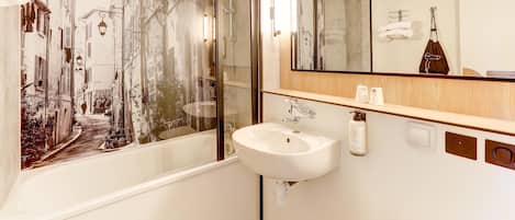Un baño con un espejo grande, una bañera, un lavabo y una ducha.