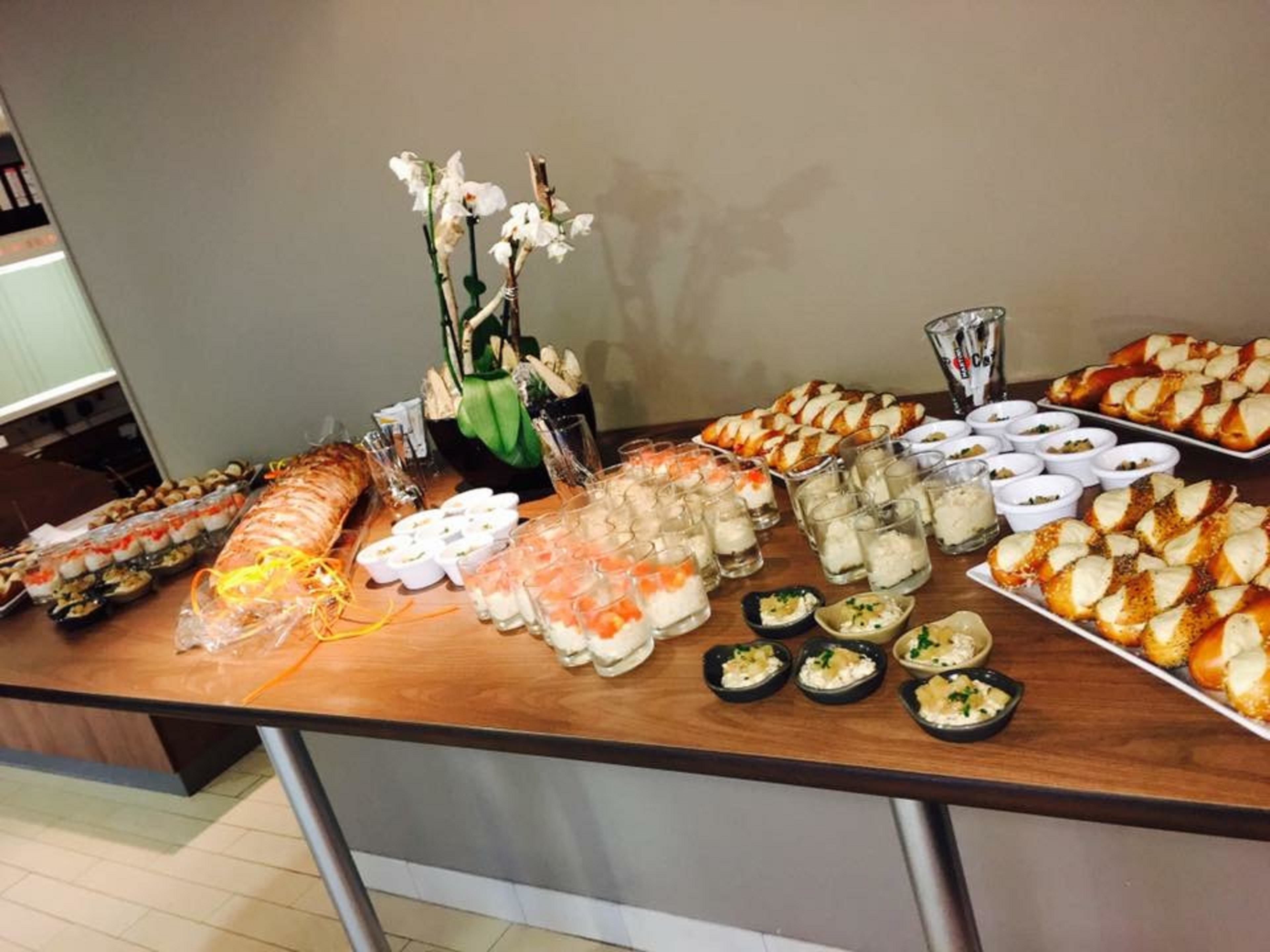 A buffet table with various food items including sushi, pastries, and small dishes.