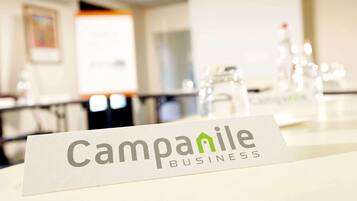 Placa da Campanile Business, com um fundo desfocado de um quarto.