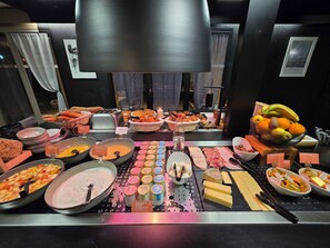 A buffet with various food items including fruits, pastries, and cheeses. - Hotel Campanile Aurillac (Aurillac)