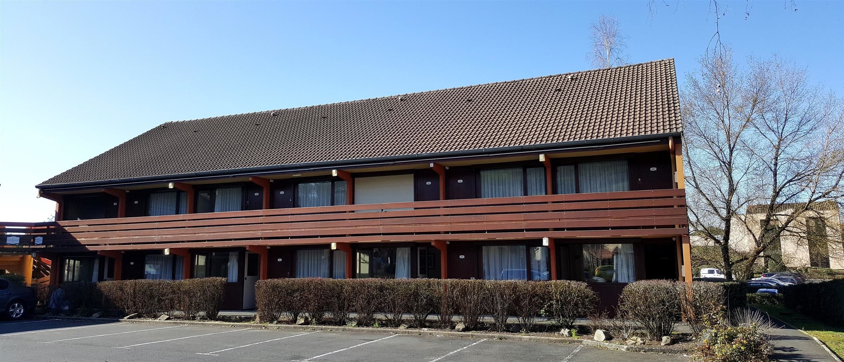 A two-story building with a tiled roof and a flat facade.