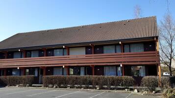 A two-story building with a tiled roof and a flat facade.