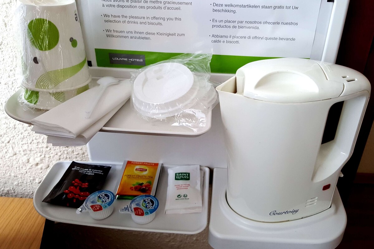 Preparació de l'esmorzar a l'habitació d'un hotel, amb una cafetera, un safata amb aliments i un menú.