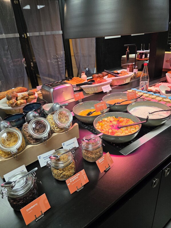 A buffet with various food items and labeled containers. - Hotel Campanile Aurillac (Aurillac)