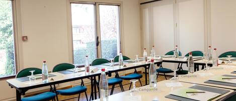 A conference room with multiple tables, chairs, water bottles, and nameplates labeled "Campanile."