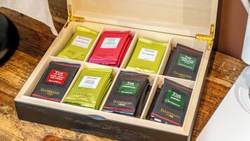 A wooden box with compartments containing various tea boxes labeled 'DAMMANN FRANKE'.