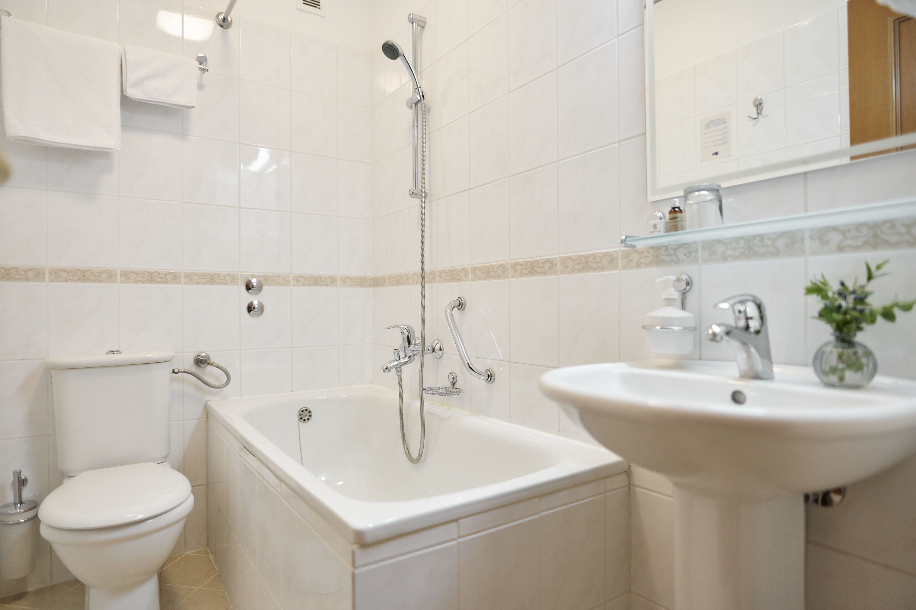Et badeværelse med toilet, badekar og vask.