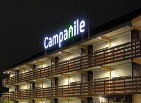 Un edificio de varios pisos con un llamativo letrero 'Campanile', balcones y un diseño arquitectónico moderno.