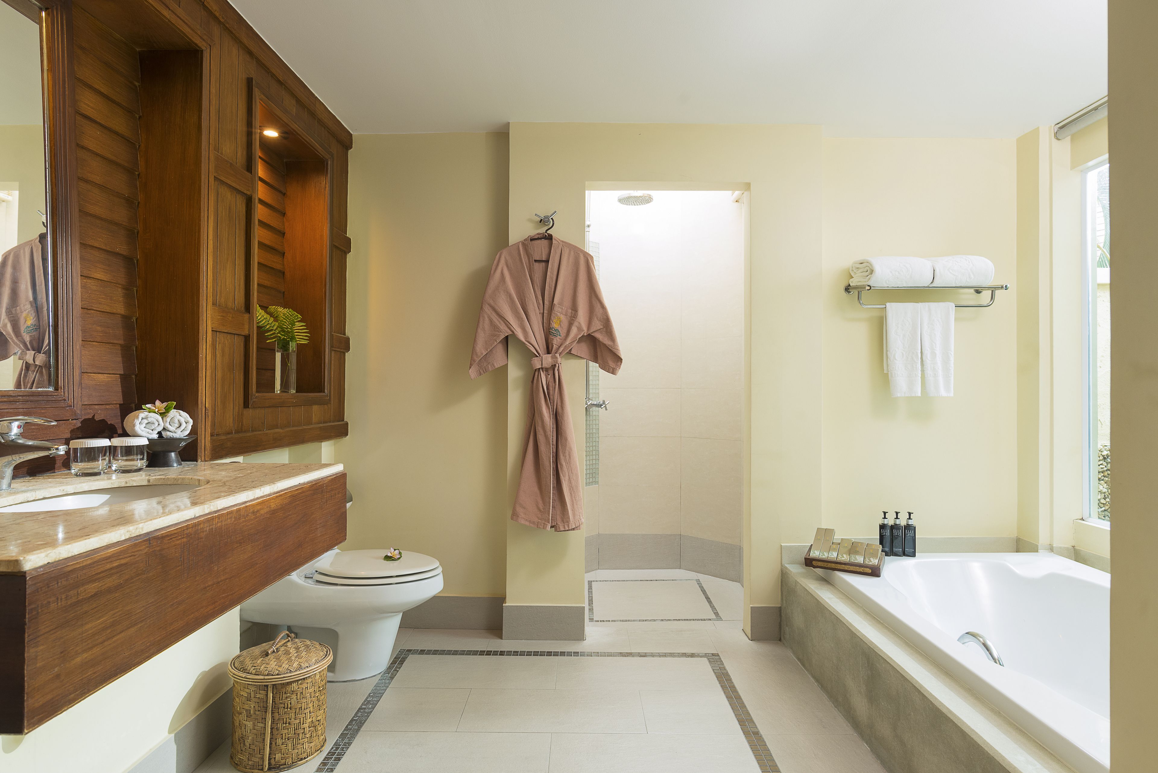 Ein Badezimmer mit einem Holzwaschtisch, einer Badewanne und einer Duschkabine.