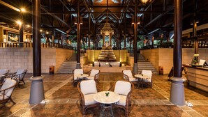 A spacious lobby with a central staircase, seating areas, and a reception desk. - Nora Beach Resort and Spa (Koh Samui)