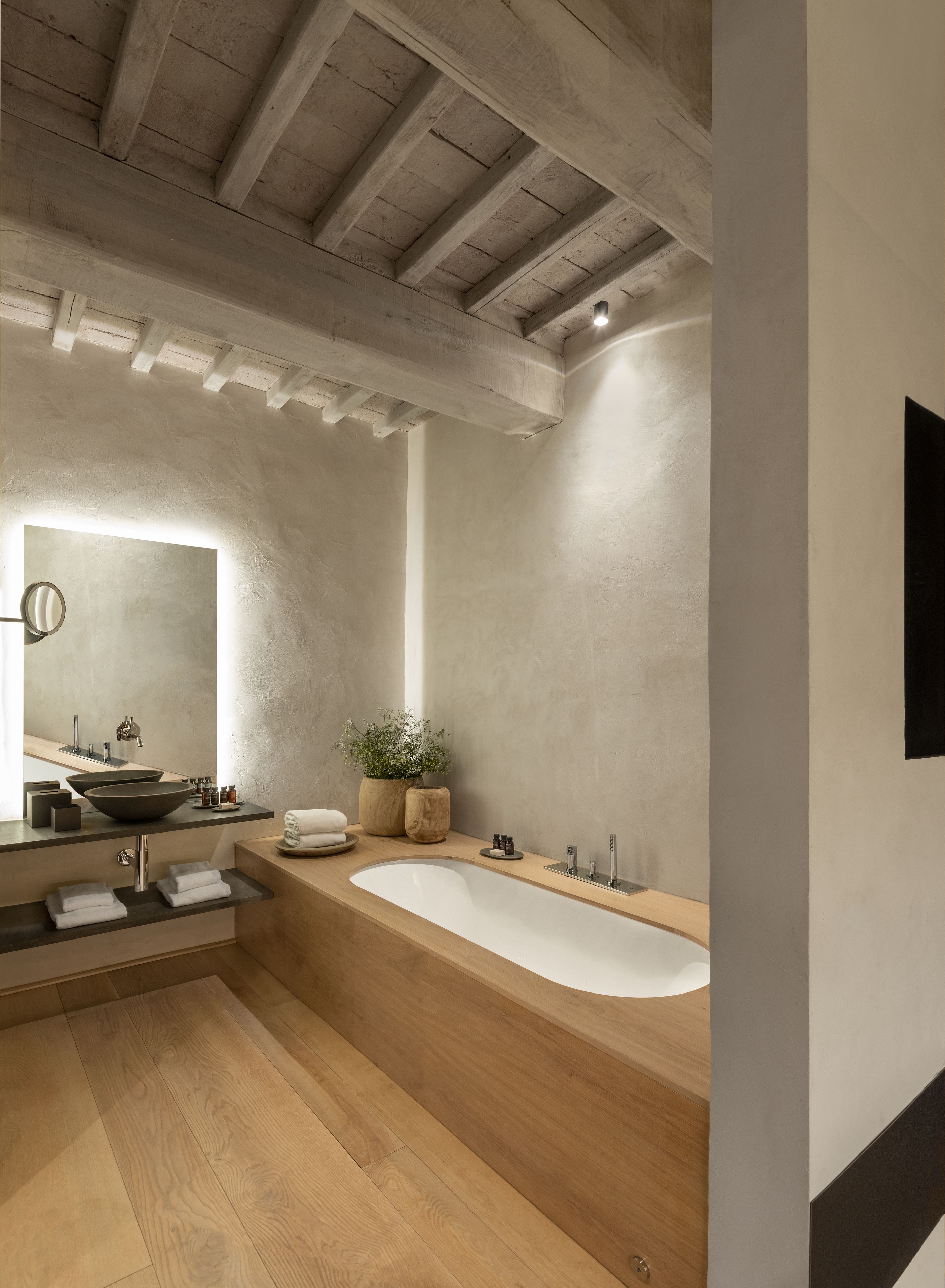 A modern bathroom with a freestanding bathtub, a double sink vanity, and a large mirror.