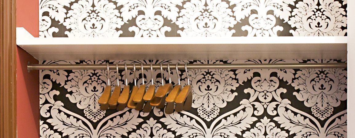 A patterned wall with a metal rod and wooden objects.