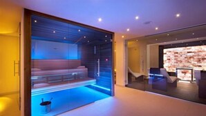 Un moderno espacio de spa con cerramiento de vidrio, suelo con calefacción y una recepción visible a través del cristal.