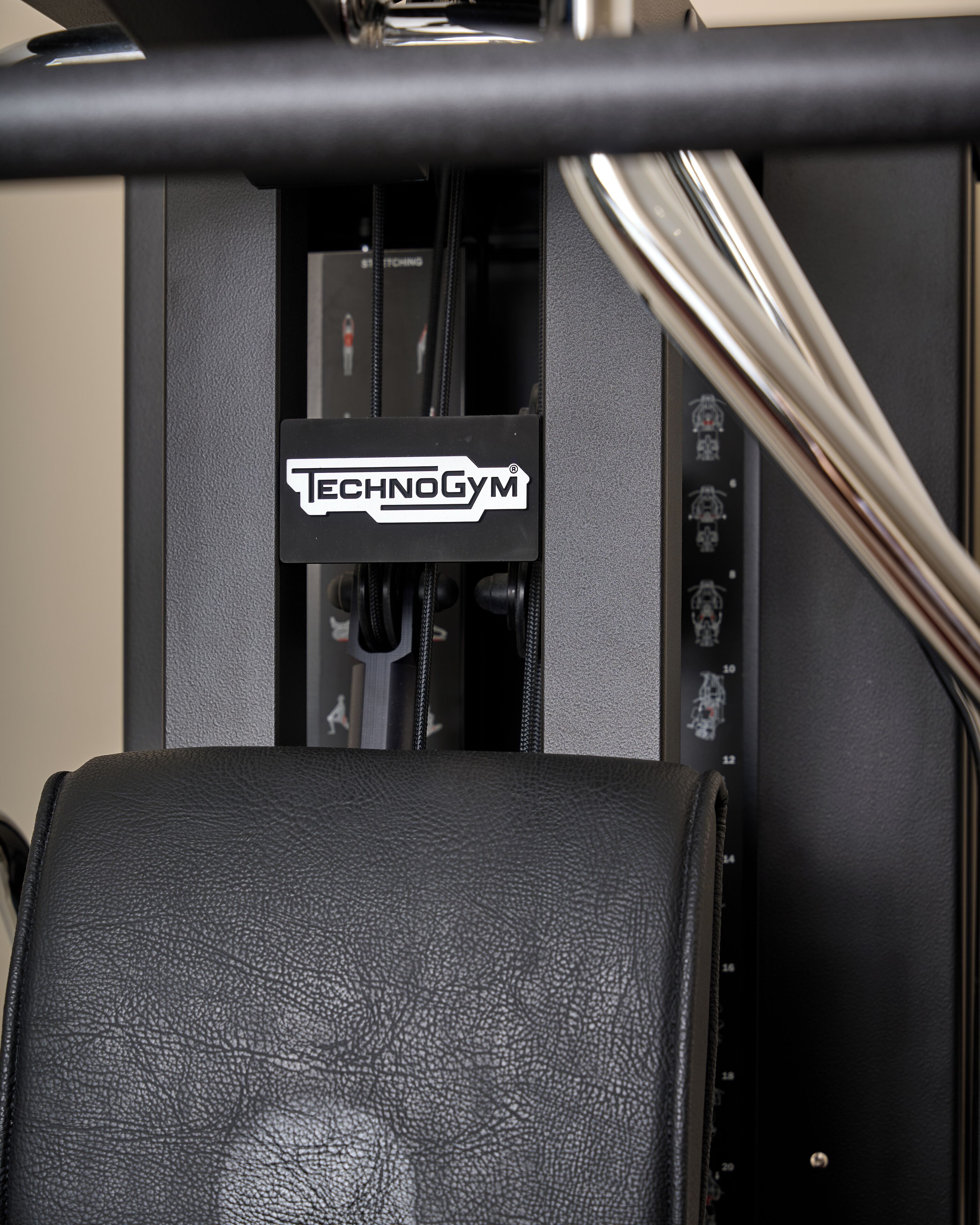 A piece of exercise equipment with a black leather seat and a control panel with the brand name "TECHNOGYM".