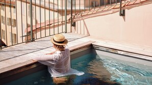 A person in a swimming pool on a rooftop with a view of buildings and a clear sky. - Grand Hôtel Dauphiné Toulon, Boutique Hôtel & Suites (Toulon)