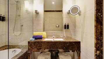 A modern bathroom with a glass-enclosed shower, a marble sink, and a large mirror.