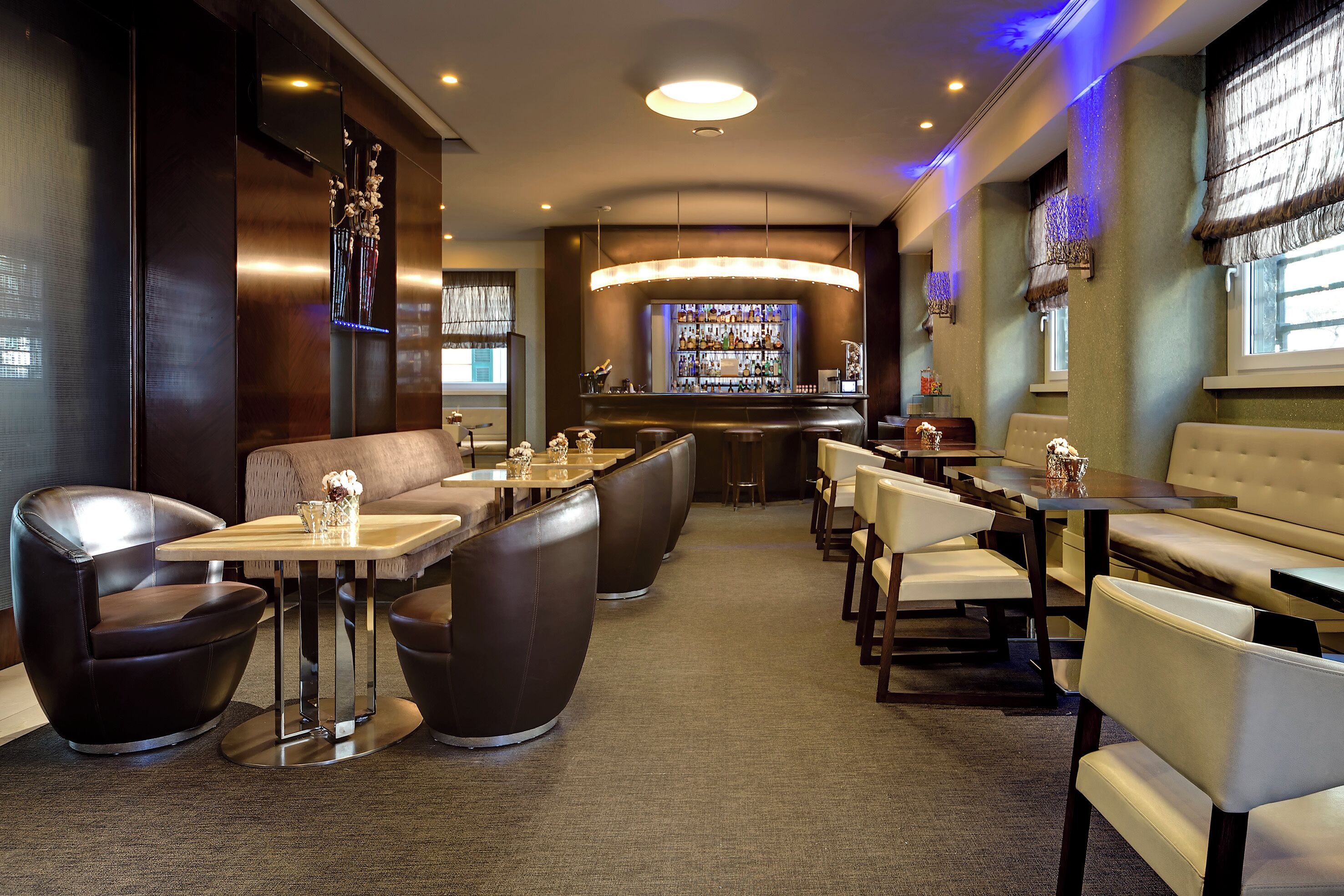 Un área de bar moderna con asientos y una barra.