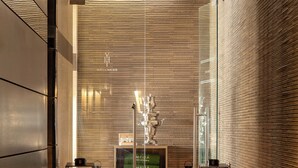A modern interior with a central seating area, glass partitions, and ambient lighting. - Melia Genova (Genoa)