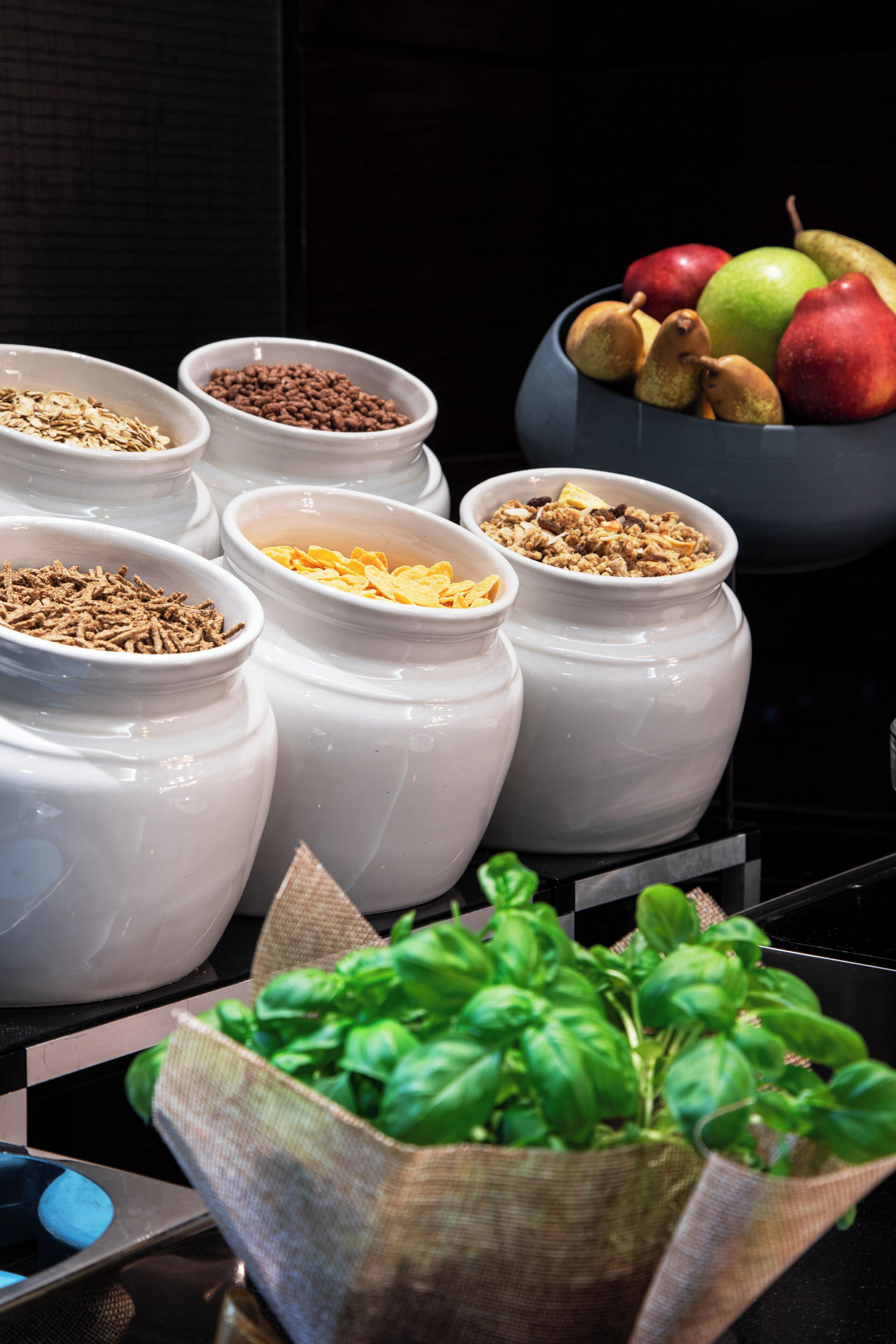 Un comptoir de cuisine avec divers aliments et un saladier rempli de fruits.