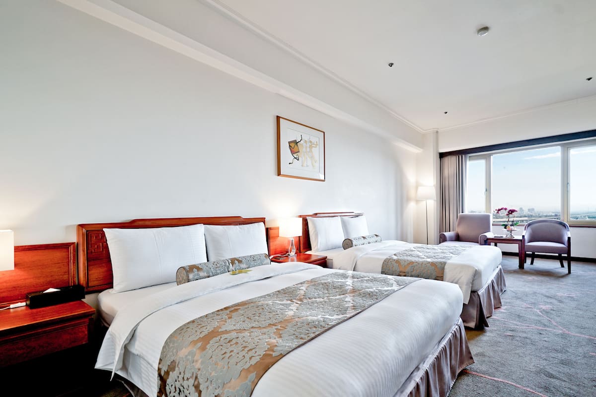 Una habitación de hotel con dos camas, un escritorio y una silla.