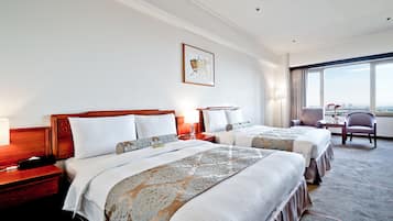 A hotel room with two beds, a desk, and a chair.
