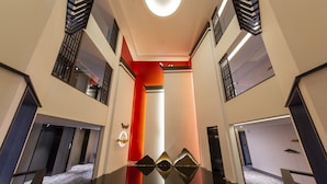 A modern hotel lobby with a central glass partition, a red accent wall, and a ceiling with a circular light fixture. - Howard Prince Hotel Taichung (Taichung)
