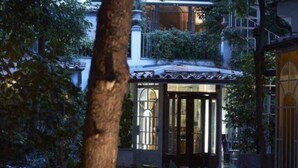 A traditional building with a tiled roof, a glass door entrance, and surrounding greenery. - Villa Laetitia (Rome)