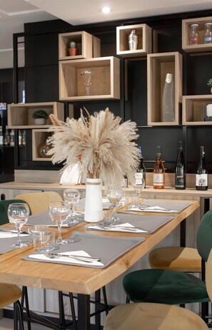 Un coin repas avec une table en bois dressée pour le repas, entourée de chaises.