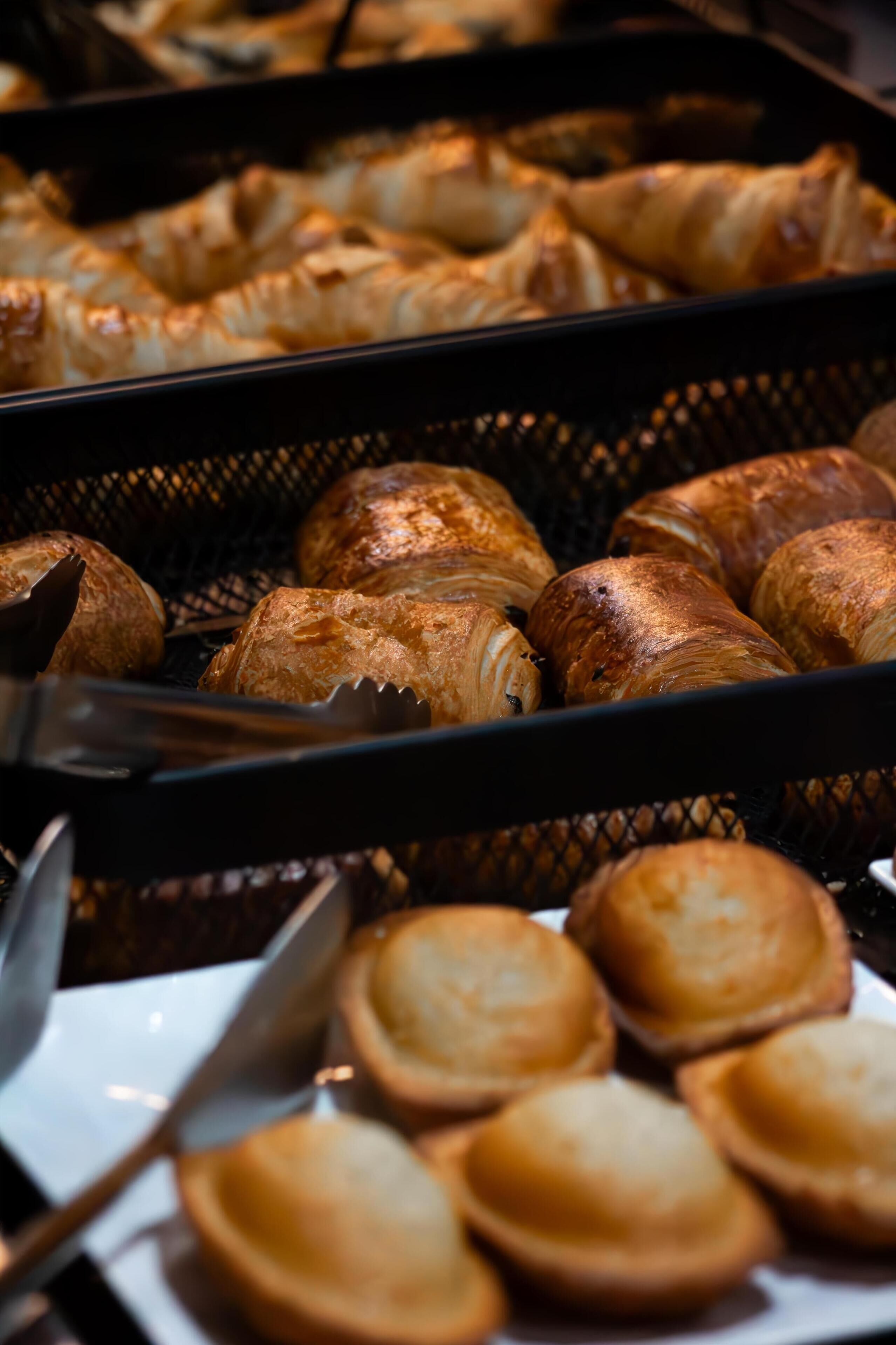 Buffet amb diverses pastes i pa, presentats en cistades.