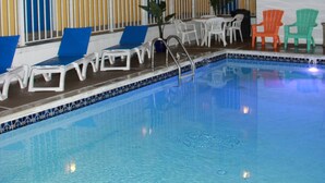 A multi-level pool area with lounge chairs and a small pool.