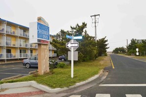 A Seaside Inn sign, a one-way street sign, and a parking lot with a yellow line.