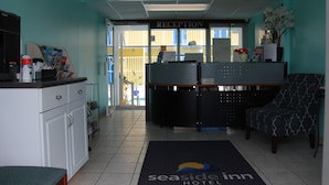 A reception area with a reception desk, a seating area with a patterned chair, and a reception sign.