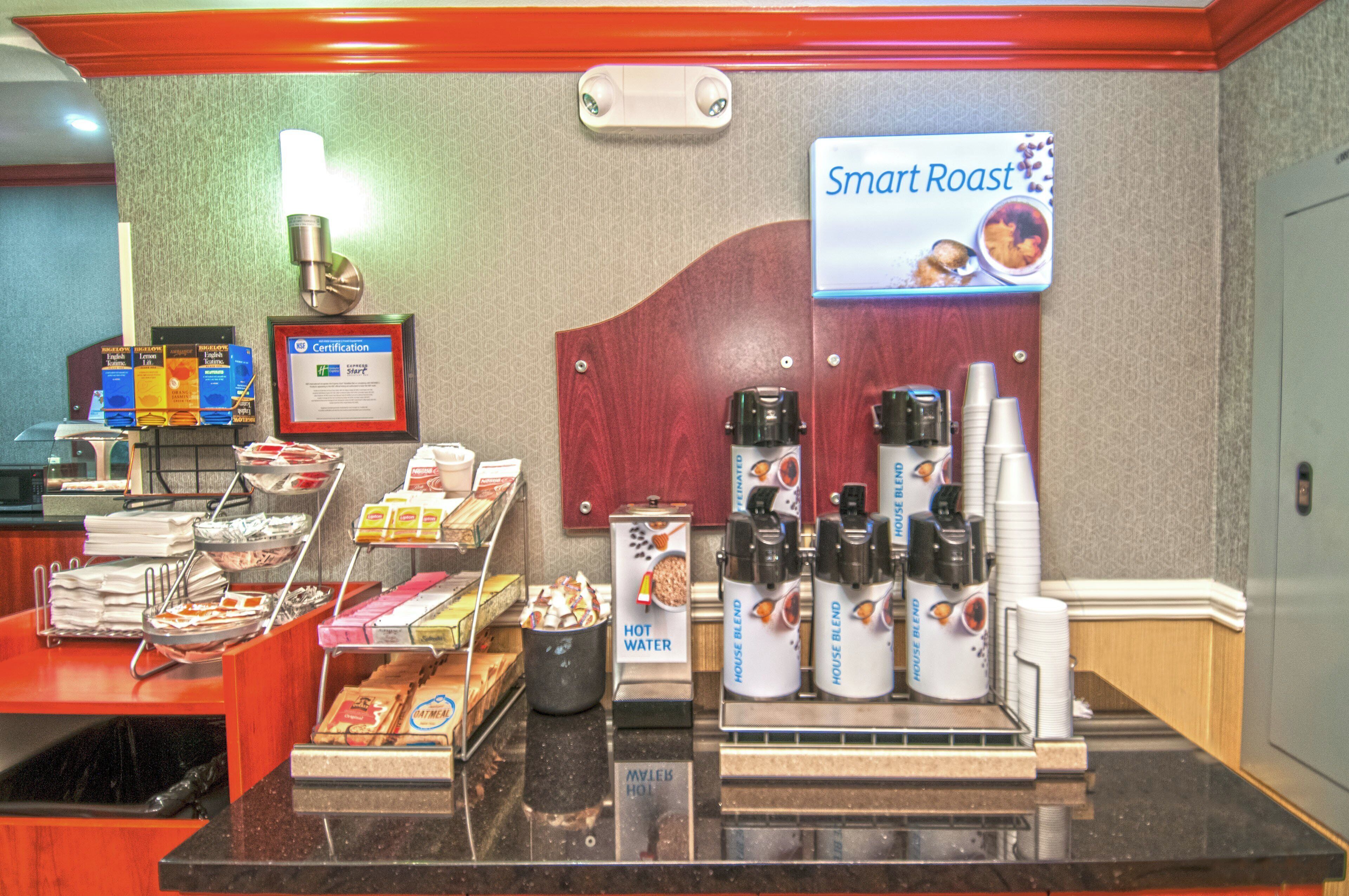 A coffee station with a sign reading 'Smart Roast,' a framed certification, and various coffee products.
