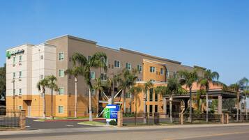 A multi-story hotel with a modern design, featuring a prominent sign for Holiday Inn Express & Suites.