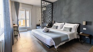 A modern hotel room with a large bed, a desk, and a view of the city. - Albergo Stella Del Mare (Chiavari)